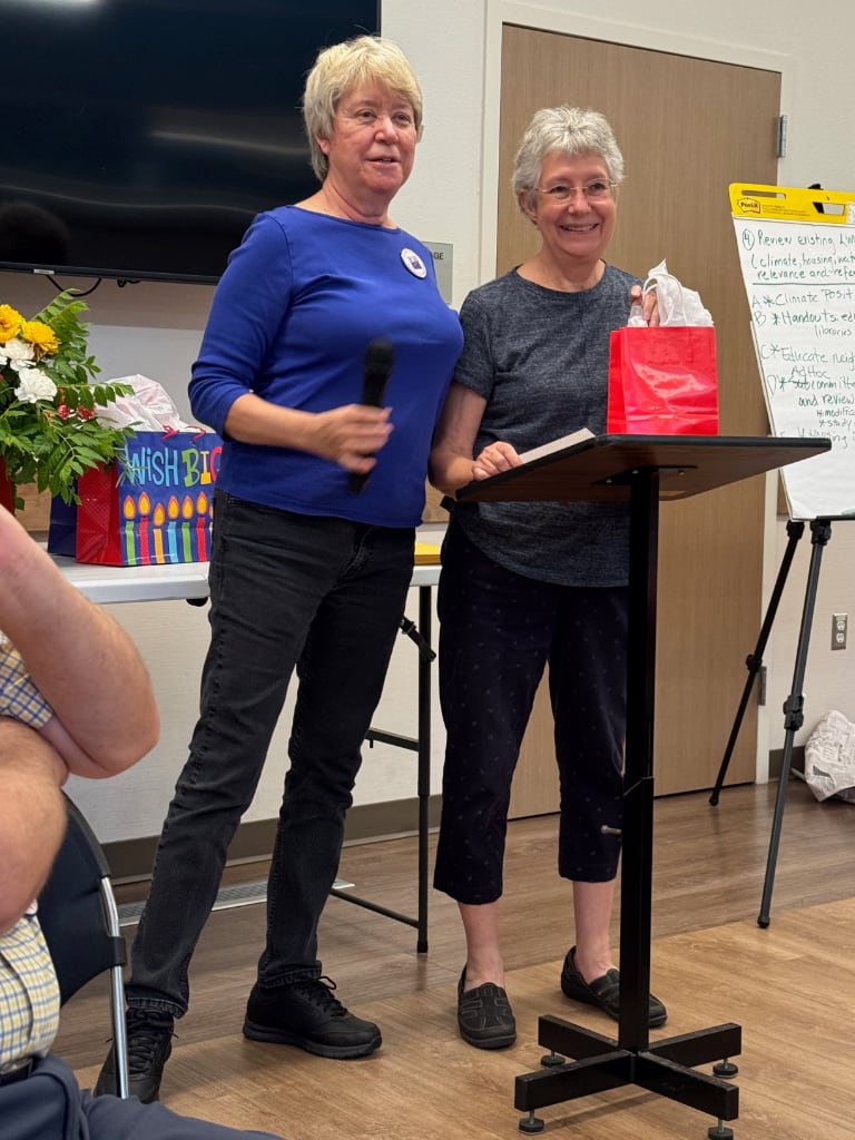 Two women at a podium with a gift bag