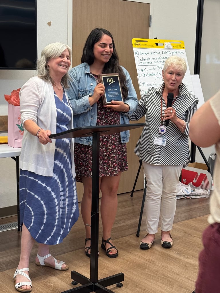 Three women awarding Komal Hak a plaque at the Yolo County LWV Annual meeting.