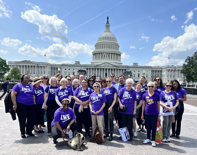 Around 30 LWV members in purple shirts in front of the White House