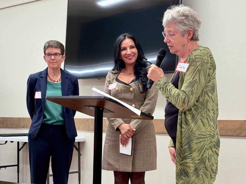 Three women at a podium