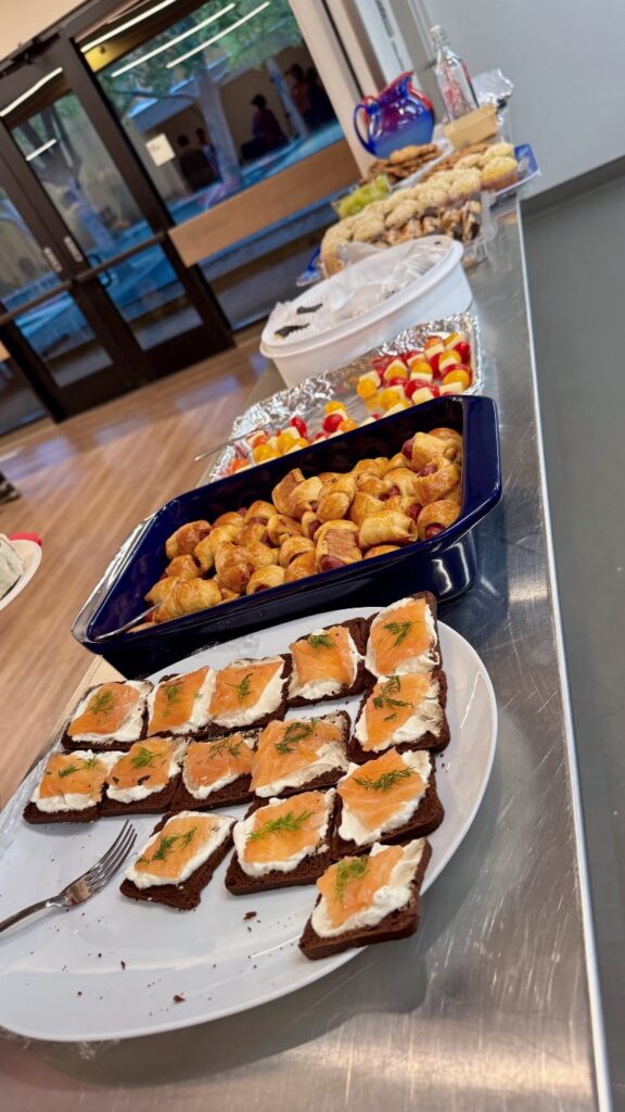 Various pot luck style foods on a metal counter