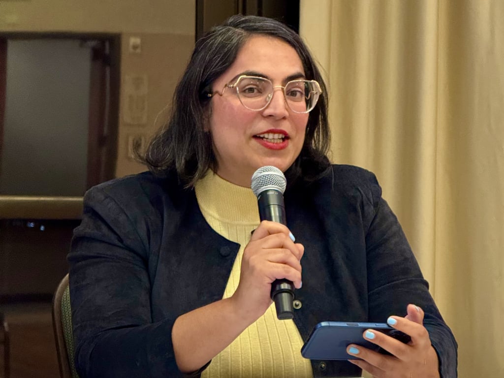 A woman with microphone presenting script
