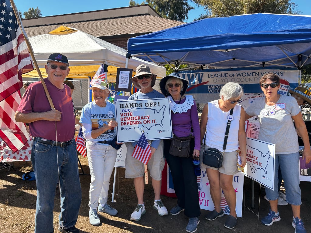 Six league members with signs and American flag