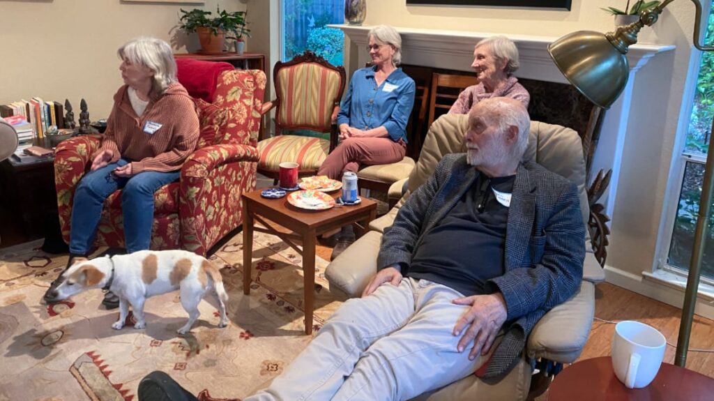 People in a living room setting listening to someone off screen