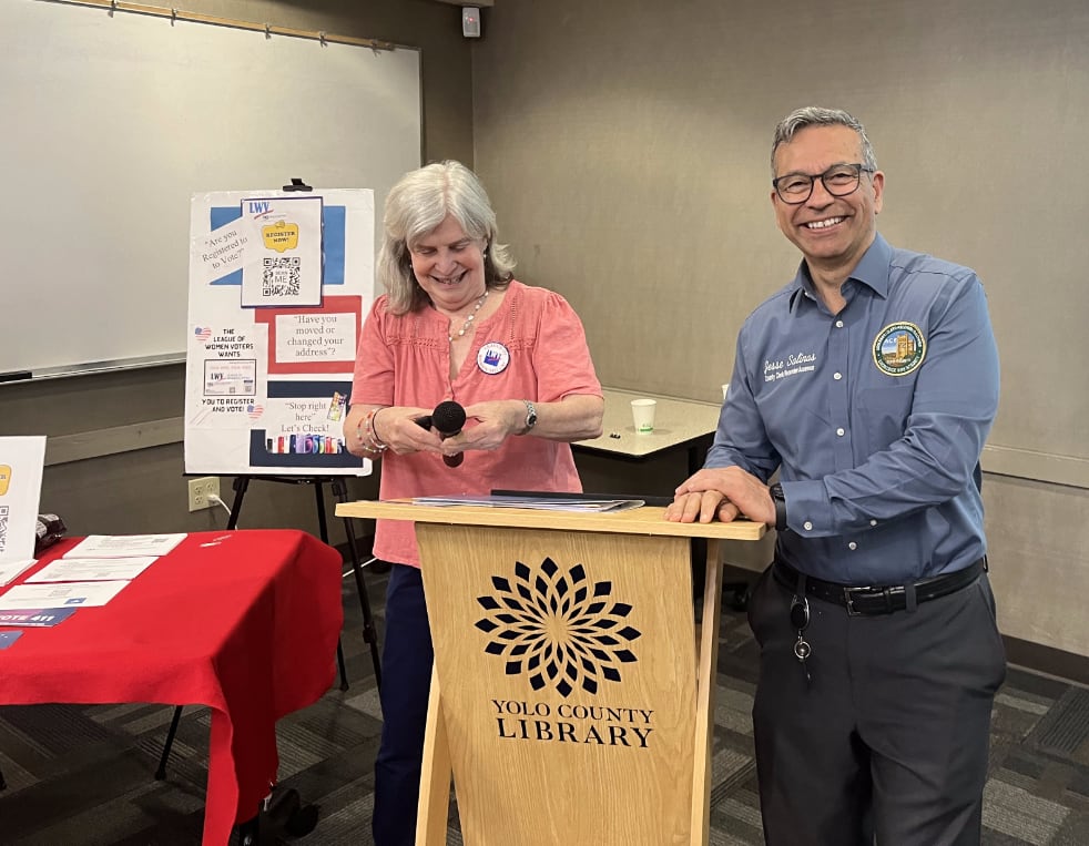 Two smiling people at a podium