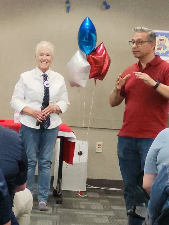 A casually dressed woman and man at an art contest awards event