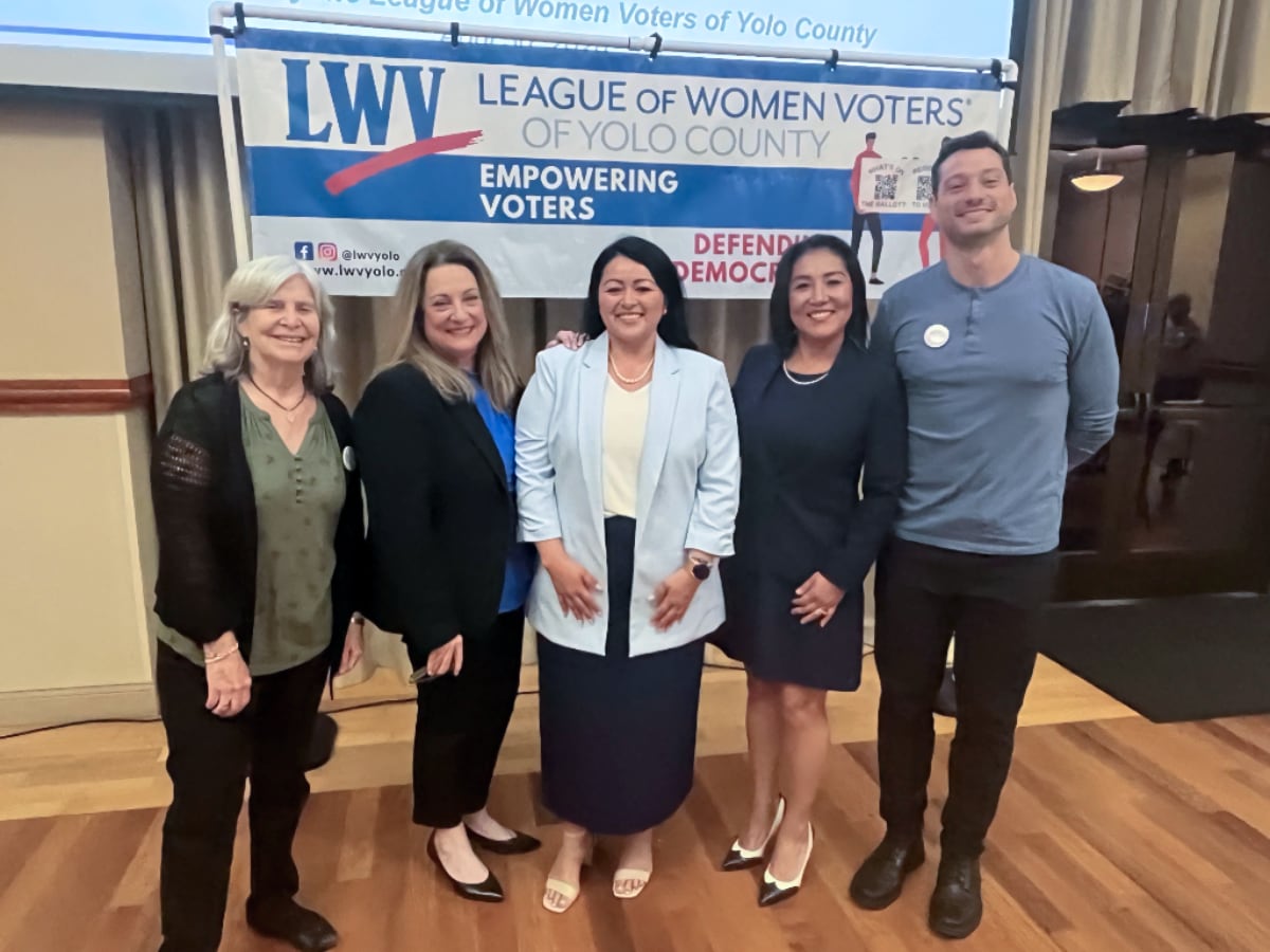 Four women and a man in front of the LWV of Yolo County banner
